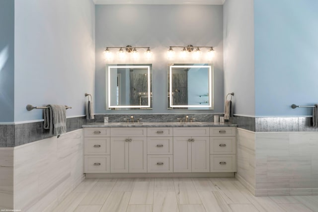 bathroom featuring vanity and tile walls