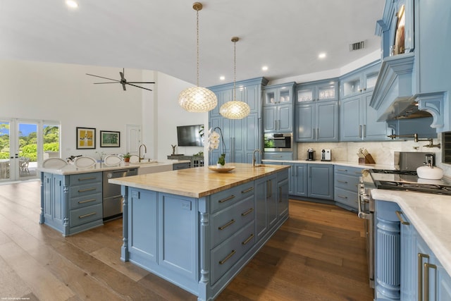 kitchen with decorative light fixtures, blue cabinets, stainless steel appliances, and a center island