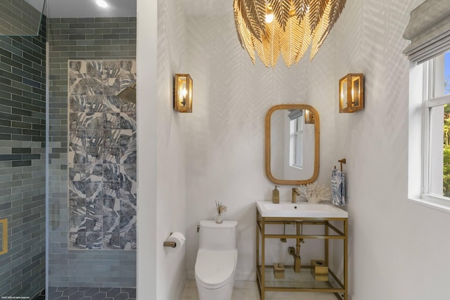 bathroom featuring toilet, sink, and tiled shower