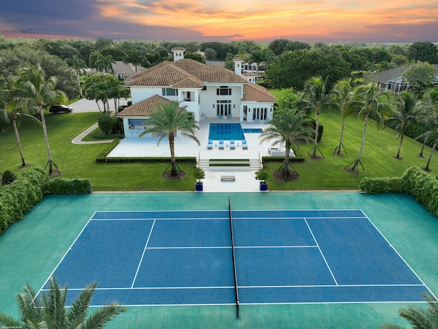 view of sport court featuring a swimming pool and a patio