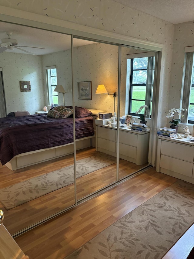 bedroom featuring light hardwood / wood-style flooring, a closet, and ceiling fan