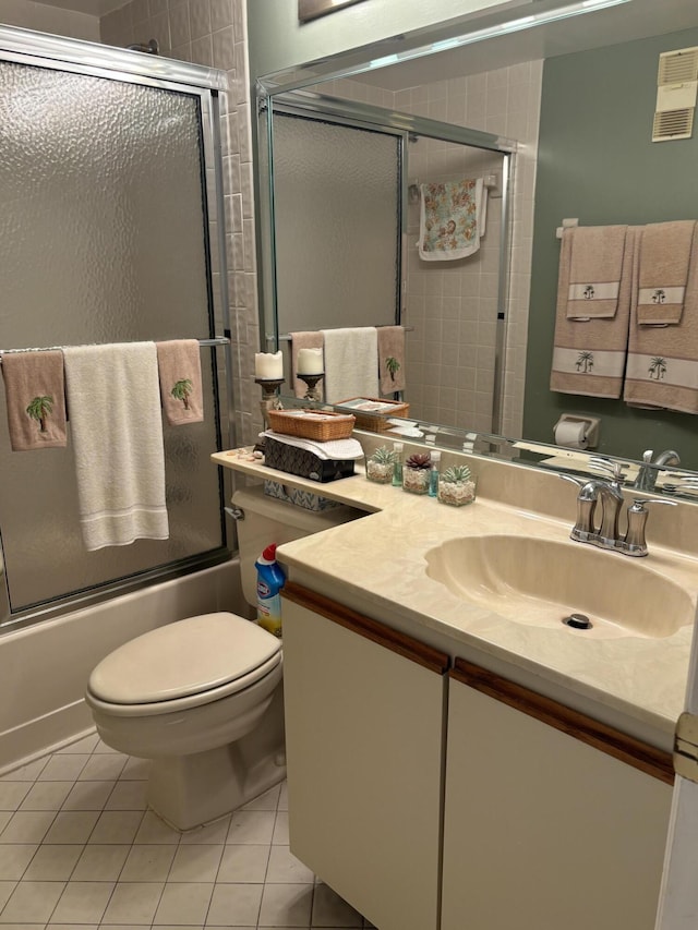 full bathroom featuring tile patterned flooring, vanity, toilet, and shower / bath combination with glass door