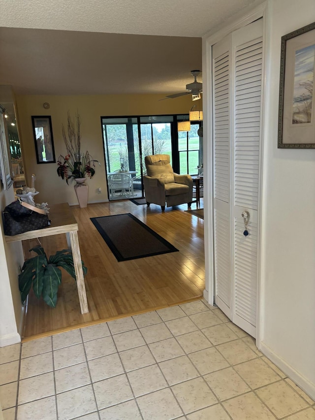 hall with light tile patterned floors and a textured ceiling