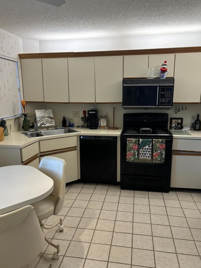 kitchen with light tile patterned flooring, sink, white cabinetry, and black appliances