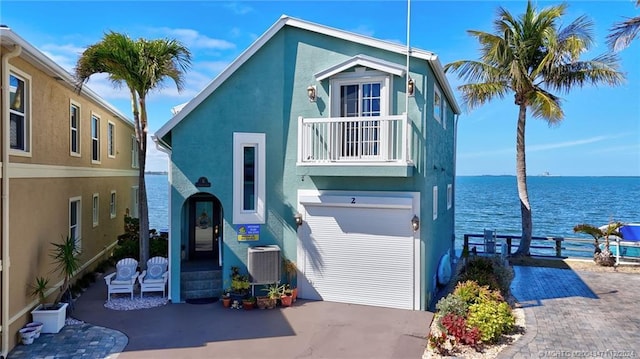 back of house featuring a water view, a garage, and central air condition unit