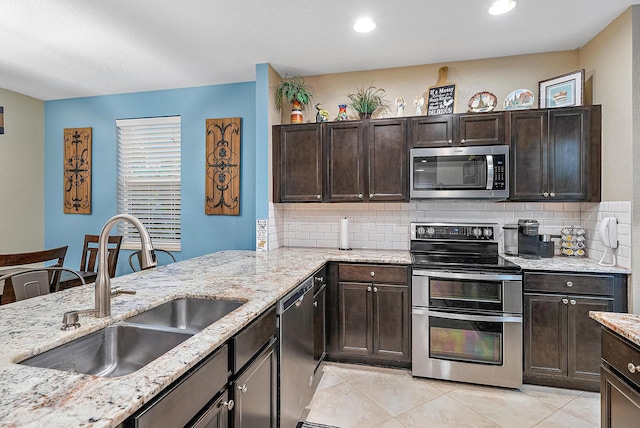 kitchen featuring tasteful backsplash, dark brown cabinetry, stainless steel appliances, sink, and light tile patterned floors