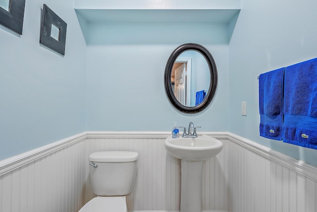6070 SE Split Oak Trl, Hobe Sound, FL 33455 - bathroom with wainscoting, toilet, and a sink