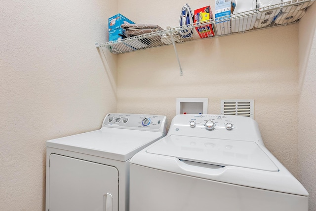 6070 SE Split Oak Trl, Hobe Sound, FL 33455 - laundry area featuring washer and clothes dryer and a textured wall
