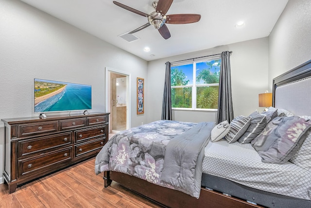 bedroom featuring light wood-type flooring, connected bathroom, and ceiling fan