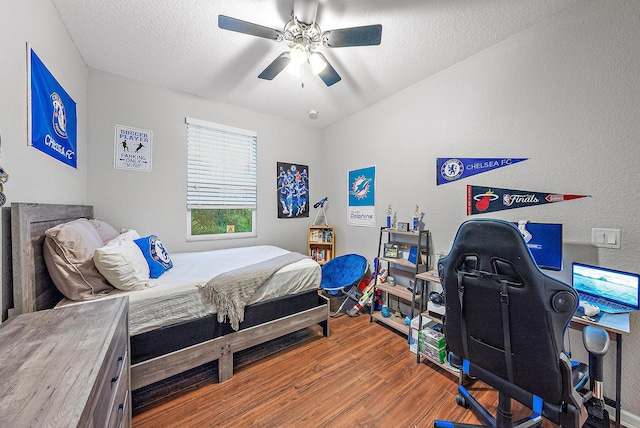 bedroom with a textured ceiling, hardwood / wood-style flooring, and ceiling fan