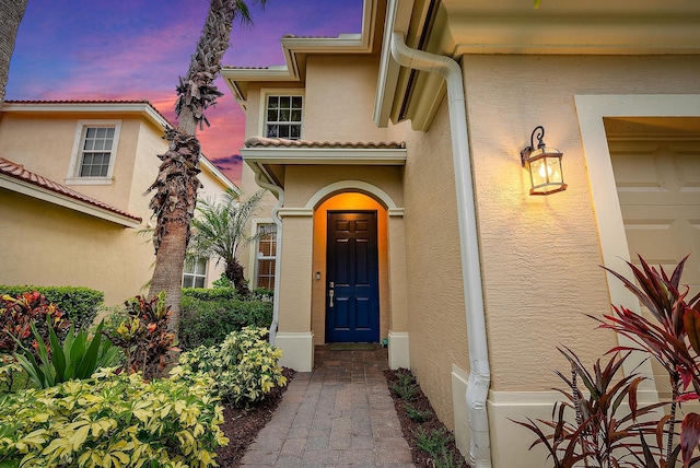 6070 SE Split Oak Trl, Hobe Sound, FL 33455 - exterior entry at dusk with stucco siding