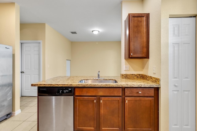 kitchen featuring sink, light stone counters, kitchen peninsula, light tile patterned floors, and appliances with stainless steel finishes