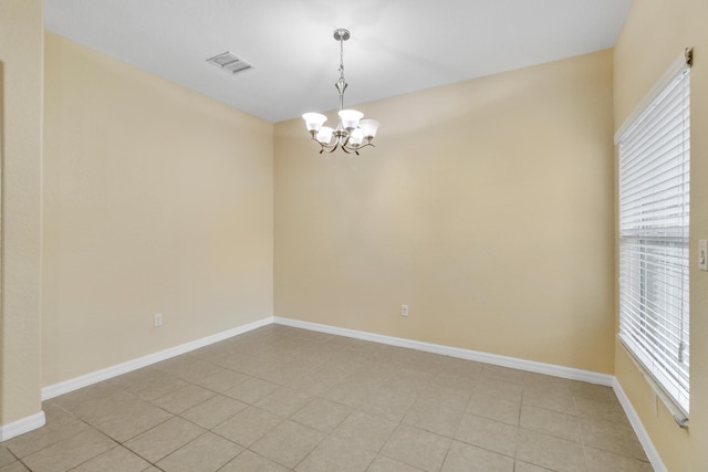 spare room with light tile patterned floors and a chandelier