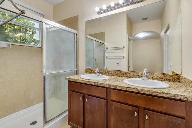 bathroom with vanity and a shower with door