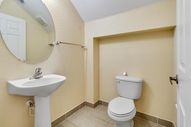 bathroom with sink, tile patterned flooring, a textured ceiling, and toilet