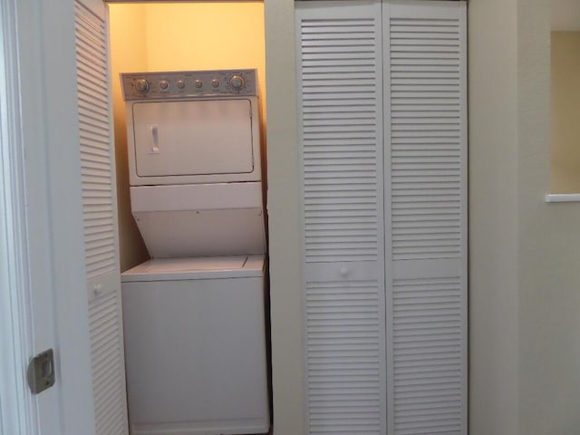 clothes washing area with stacked washing maching and dryer