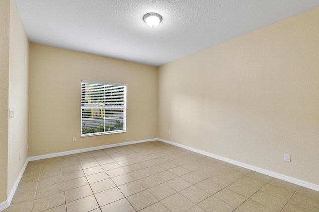 empty room featuring light tile patterned floors and a textured ceiling