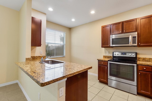 kitchen featuring sink, light stone countertops, light tile patterned floors, kitchen peninsula, and stainless steel appliances