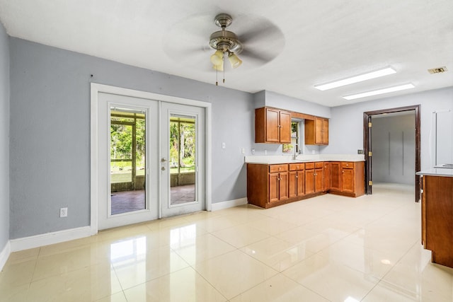 kitchen with french doors, light tile patterned floors, ceiling fan, and sink