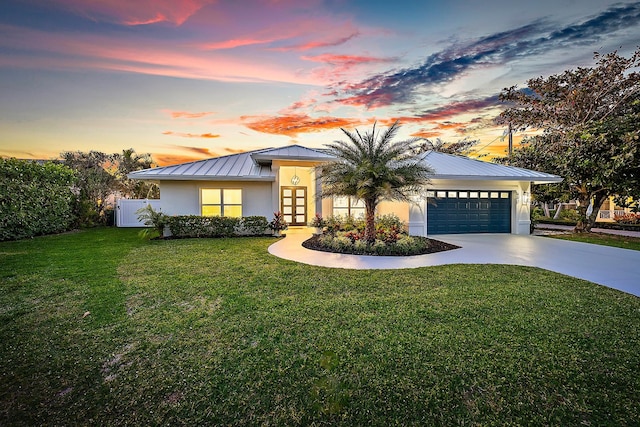 view of front of home featuring a lawn and a garage