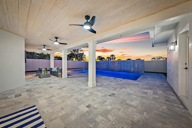 pool at dusk featuring a patio and ceiling fan