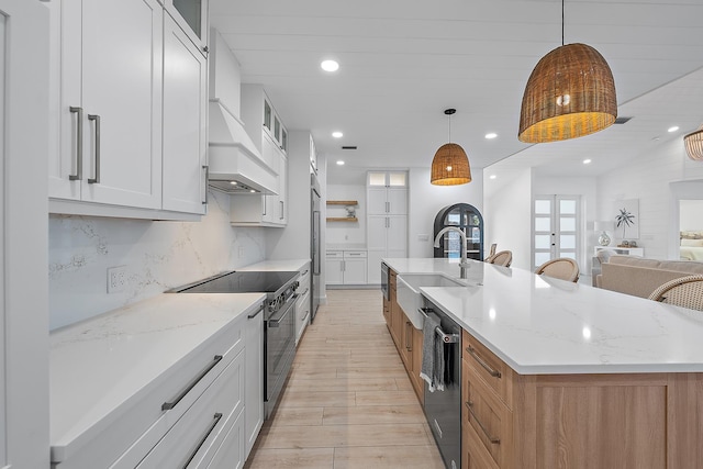 kitchen with light stone countertops, stainless steel appliances, a spacious island, decorative light fixtures, and white cabinets