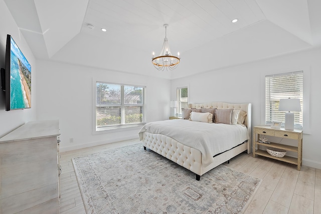 bedroom featuring light hardwood / wood-style flooring, a raised ceiling, and a notable chandelier