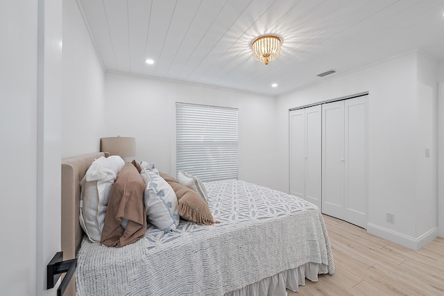 bedroom featuring a closet, ornamental molding, and light wood-type flooring