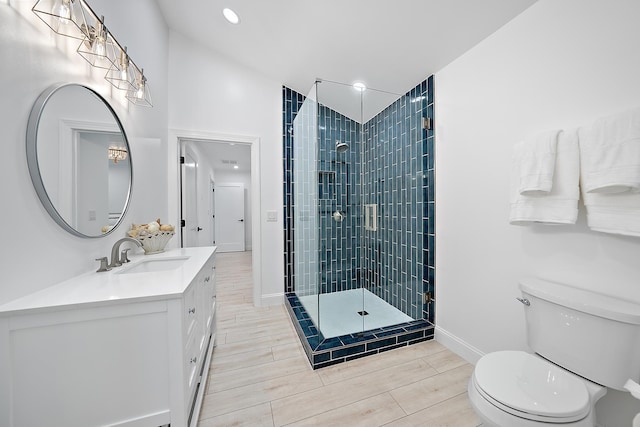 bathroom featuring vanity, toilet, and a shower with door