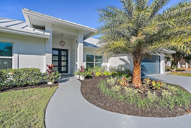 doorway to property with a garage and french doors