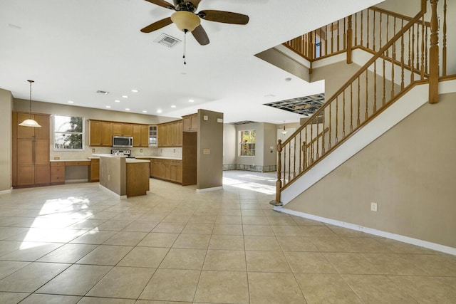 kitchen featuring decorative light fixtures, a kitchen island, light tile patterned floors, and ceiling fan