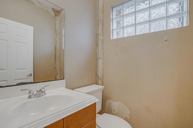 bathroom with vanity, toilet, and a wealth of natural light