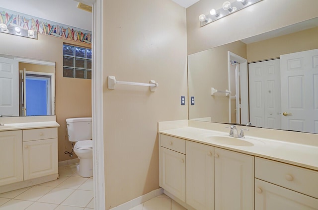 bathroom with tile patterned flooring, vanity, and toilet