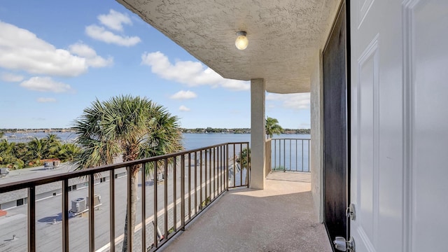 balcony with a water view and central AC unit