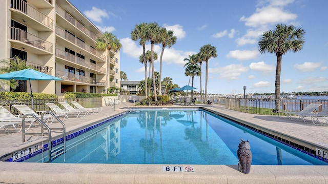 view of pool featuring a water view and a patio area