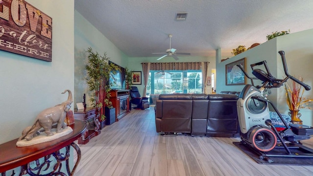 living room with light wood-type flooring, a textured ceiling, and ceiling fan