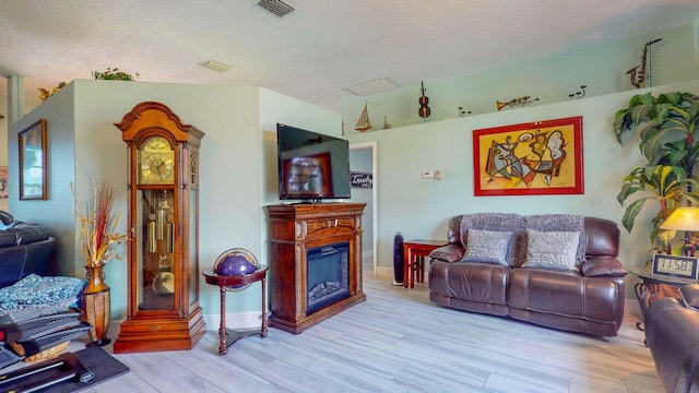 living room featuring light hardwood / wood-style flooring and a textured ceiling