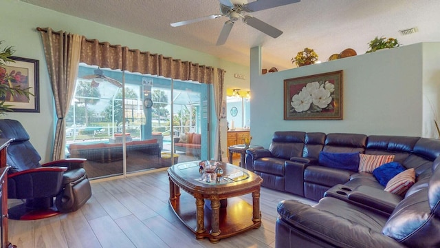 living room featuring hardwood / wood-style floors, ceiling fan, and a textured ceiling