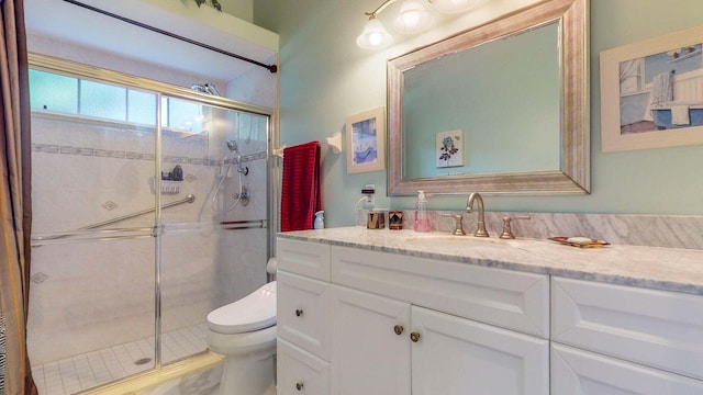 bathroom featuring vanity, toilet, and walk in shower