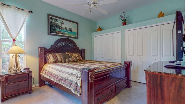 tiled bedroom featuring two closets and ceiling fan