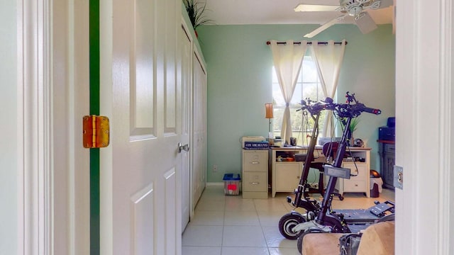 workout area featuring ceiling fan and light tile patterned floors