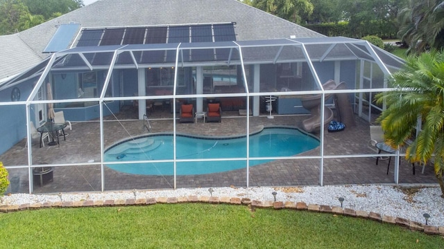 view of swimming pool featuring a patio area, a lanai, and a water slide