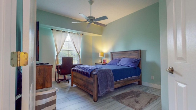 bedroom featuring light hardwood / wood-style floors, ceiling fan, and lofted ceiling