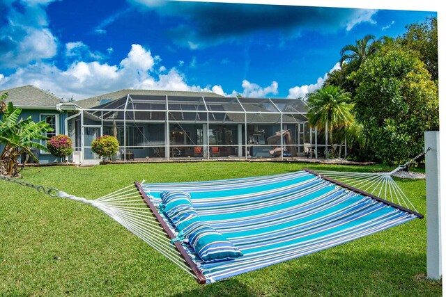 back of house featuring a lanai and a lawn