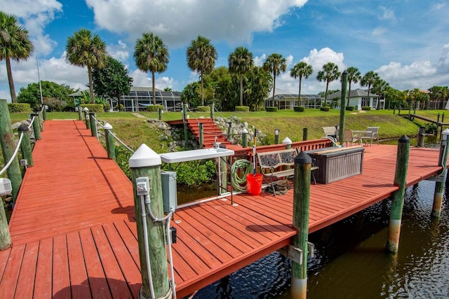 view of dock featuring a water view and a yard