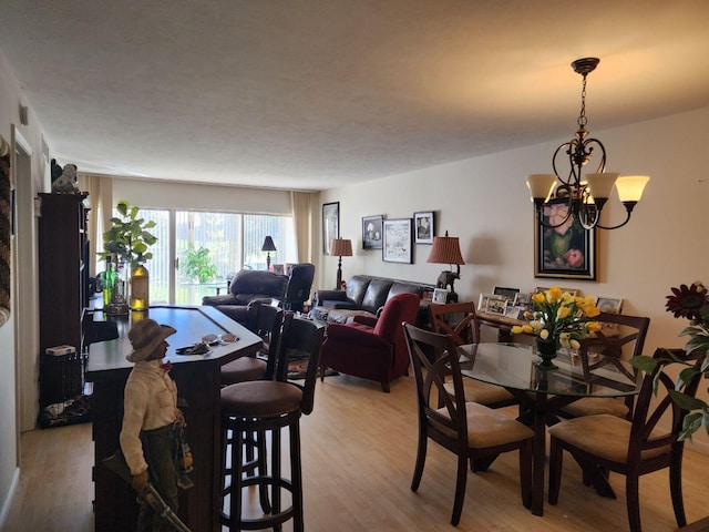 dining area with light wood-type flooring and a chandelier