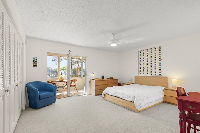 carpeted bedroom with ceiling fan, a textured ceiling, and a closet