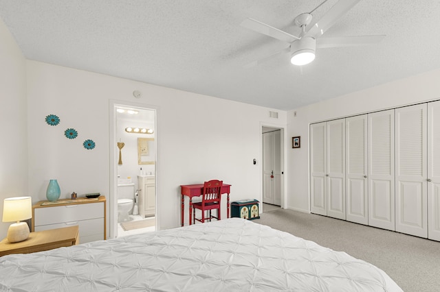 carpeted bedroom featuring ensuite bath, ceiling fan, a closet, and a textured ceiling