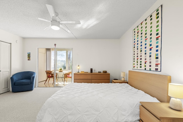 bedroom with ceiling fan, a closet, carpet, and a textured ceiling