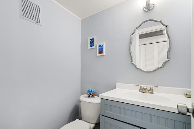 bathroom with crown molding, vanity, and toilet